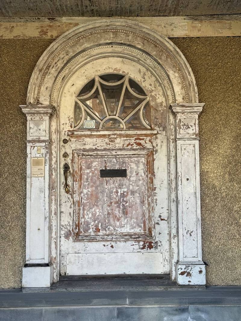 Original wood entry door before restoration, weathered finish